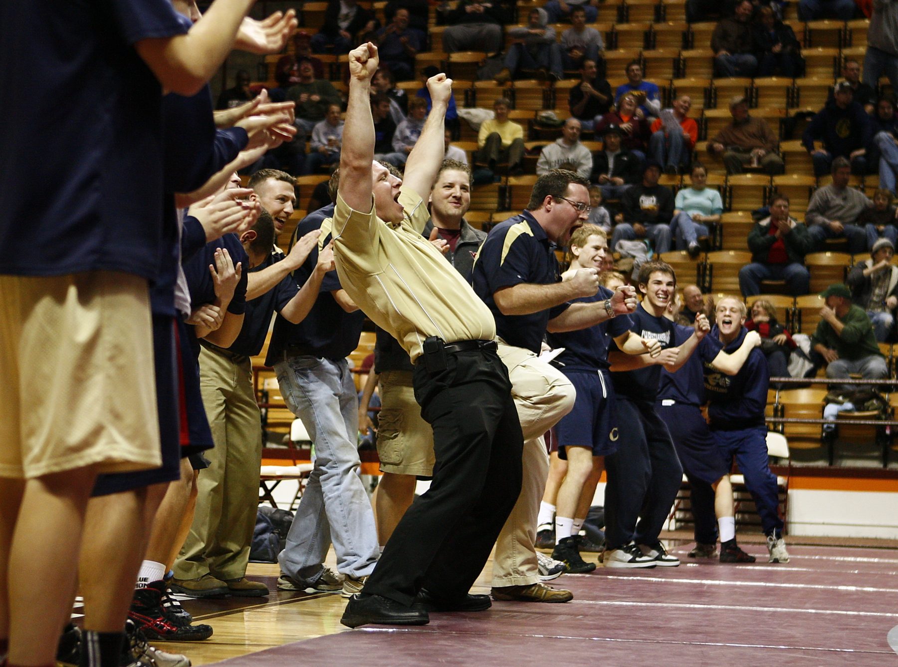 Coaches and wrestlers on the bench erupting as a state title is clinched