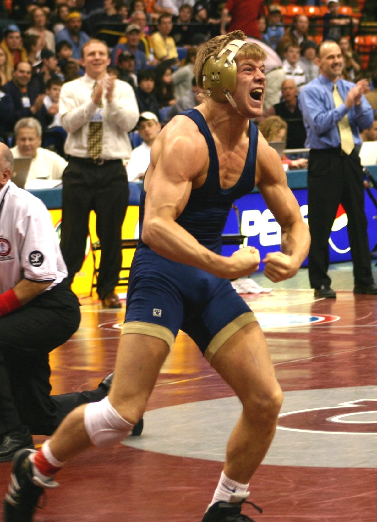 Matt Epperly roaring in celebration on the mat as the crowd stands behind him